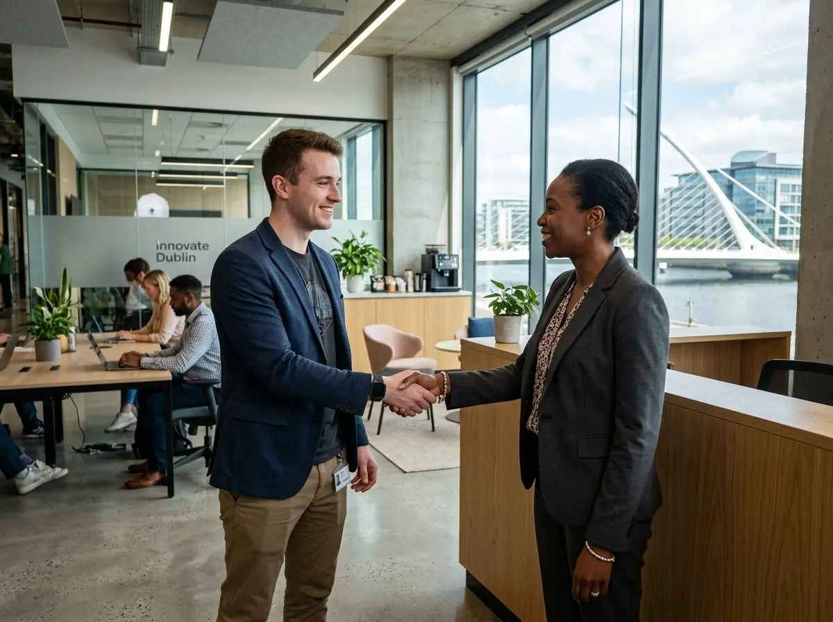 A developer shaking hands with a client in a modern Dublin office setting
